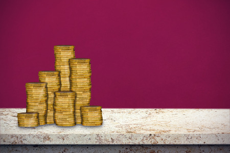 Gold coins stacked against red backgroundの写真素材