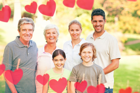 Hearts hanging on a line against family in the parkの写真素材