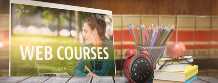 School supplies on desk against close up of big booksの写真素材