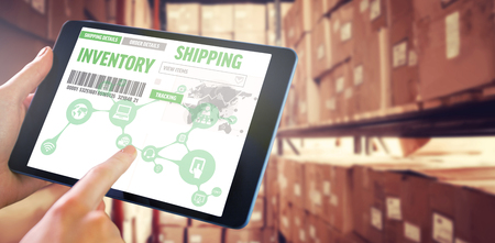 Man using tablet pc against shelves with boxes in warehouseの写真素材