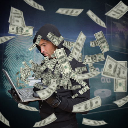 Hacker holding laptop and credir card against digital security finger print scanの写真素材