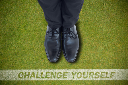 Businessmans feet in black brogues against green backgroundの写真素材