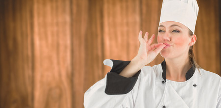 Portrait of a woman chef satisfying against wooden backgroundの写真素材
