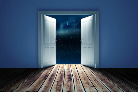 Door opening in dark room to show sky against stars twinkling in night skyの写真素材