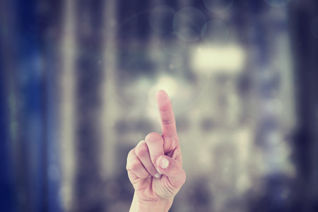 Hand of woman pointing up on blurred backgroundの写真素材