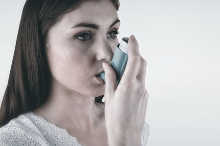 Portrait of an asthmatic womanagainst blue backgroundの写真素材