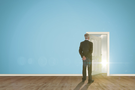 Rear view of mature businessman posing against open door on green wallの写真素材
