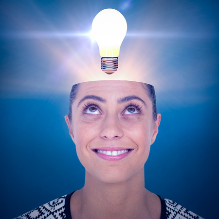 Beautiful woman looking up over white background against blue backgroundの写真素材