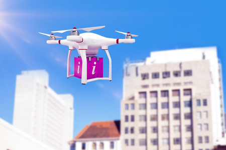 A drone bringing a pink cube against low angle view of city buildingsの写真素材