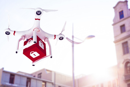 A drone bringing a red cube against low angle view of city buildingsの写真素材