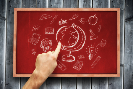 Hand pointing against blackboard with copy space on wooden boardの写真素材