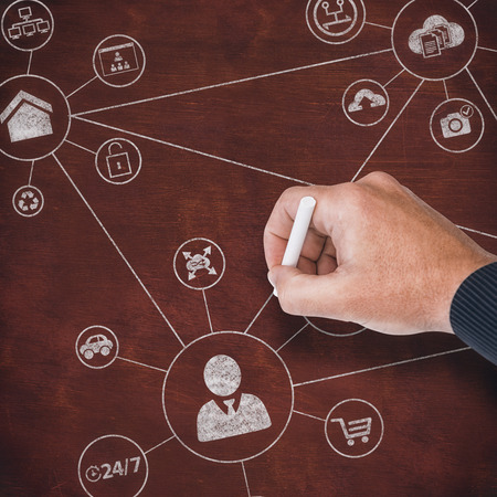 Hand writing with chalk against image of a deskの写真素材