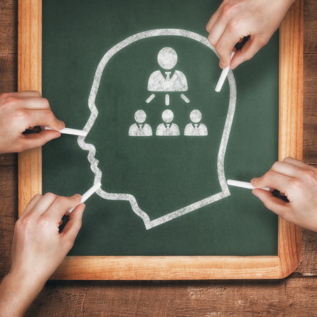 Multiple hands writing with chalk against chalkboardの写真素材