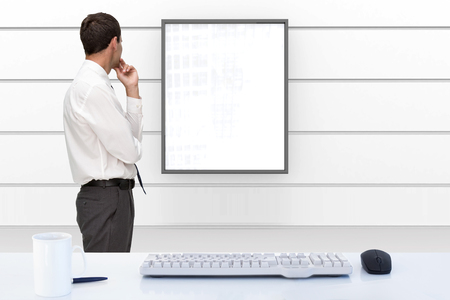 Thoughtful classy businessman looking away against display in white room Thoughtful classy businessman looking away against display in white room