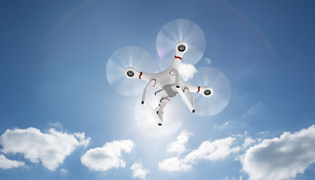 Image of a drone against cloudy sky with sunshineの写真素材