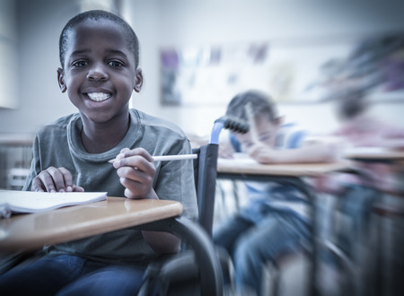 Disabled pupil smiling at camera in classroom at the elementary school