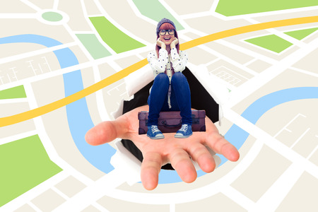 Smiling hipster woman sitting on suitcase  against digital image of map