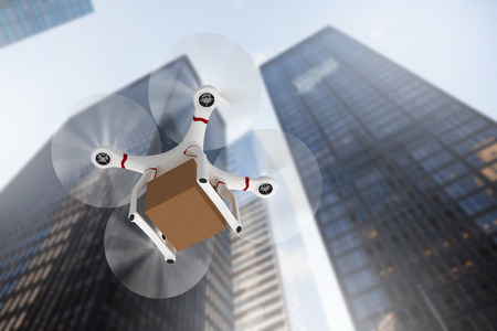 Digital image of a drone holding a cardboard against skyscraperの写真素材