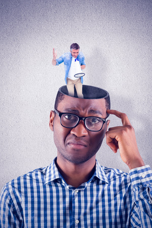 Man in casual clothes speaking on megaphone against grey wallの写真素材