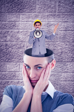 Architect with hard hat shouting with a megaphone against image of a wallの写真素材