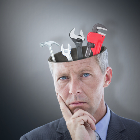 Workman holding pipe wrench against digitally generated grey vignette backgroundの写真素材