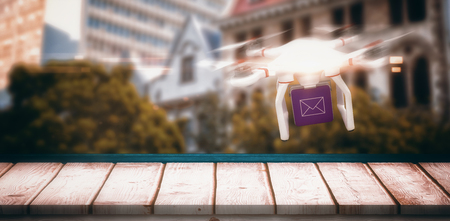 Digital image of a drone holding a cube against low angle view of city buildings on sunny day
