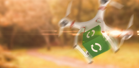 Digital image of a drone holding a cube against peaceful autumn scene in forestの写真素材