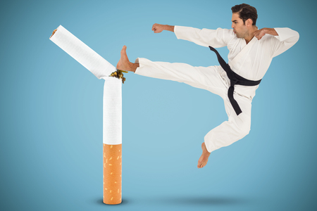 Fighter performing karate stance against blue backgroundの写真素材