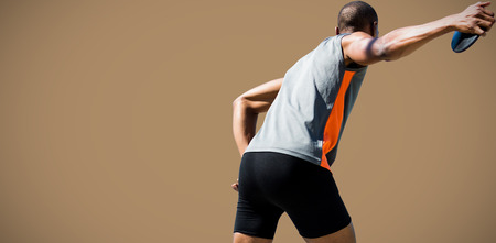 Rear view of sportsman practising discus throw against maroon backgroundの写真素材