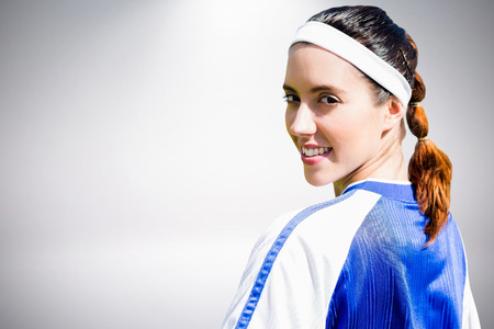 Portrait of woman soccer player against grey backgroundの写真素材