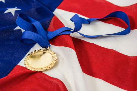 Close-up of a gold medals on american flagの写真素材