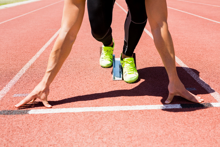 Athlete on a starting block about to run on running trackの写真素材