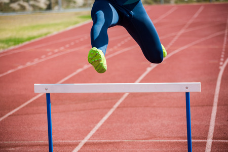 Athlete jumping above the hurdle during the raceの写真素材