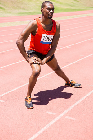 Athlete warming up on the running track on a sunny dayの写真素材