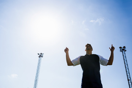 Happy soccer player posing after victory in stadium
