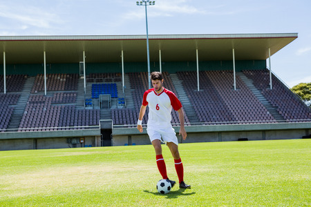 Football player practicing soccer in a stadiumの写真素材