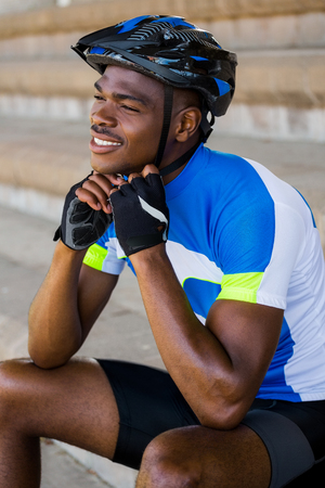 Happy athlete putting on cycling helmetの写真素材