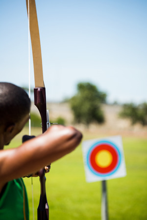 Rear view of athlete practicing archery in stadiumの写真素材