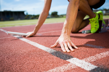 Athlete ready to start the relay race on the running track