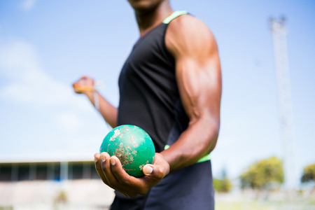 Mid section of athlete holding hammer throw in stadiumの写真素材