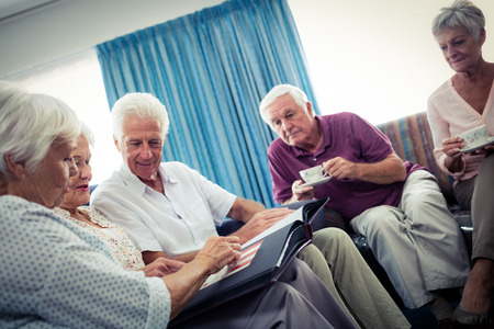 Seniors looking at pictures in the retirement houseの写真素材
