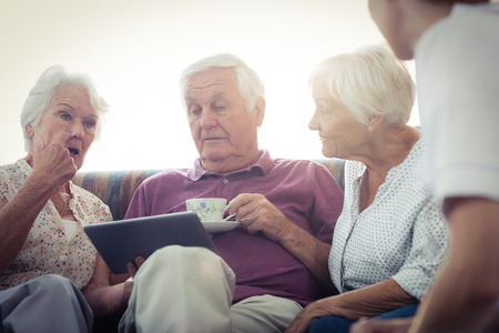 Seniors using a tablet computer in the retirement houseの写真素材