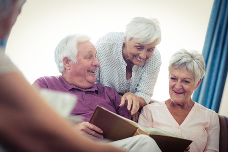 Seniors looking at pictures in the retirement houseの写真素材
