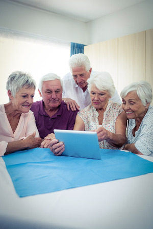 Group of seniors using a tablet computer in the retirement houseの写真素材