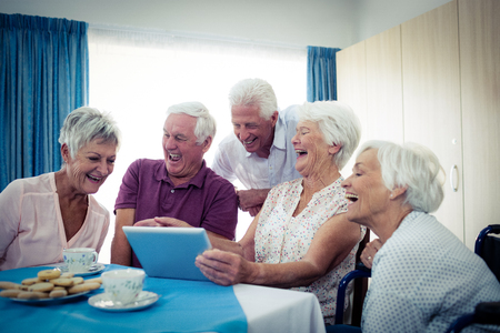 Group of seniors using a tablet computer in the retirement houseの写真素材