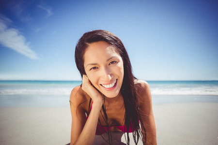 Portrait of young woman lying on beachの写真素材