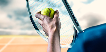 Tennis player holding a racquet ready to serve  against composite image of tennis netの写真素材