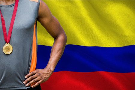 Portrait of sportsman chest with medals  against digitally generated colombia national flagの写真素材
