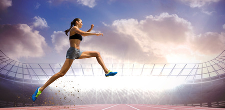 Profile view of sportswoman jumping  against race track