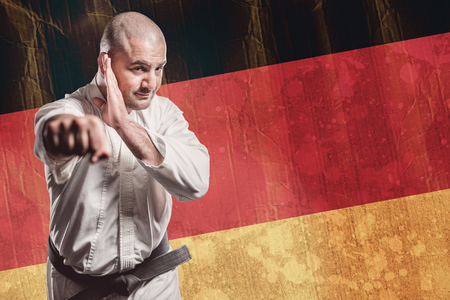 Fighter performing karate stance against germany flag in grunge effectの写真素材